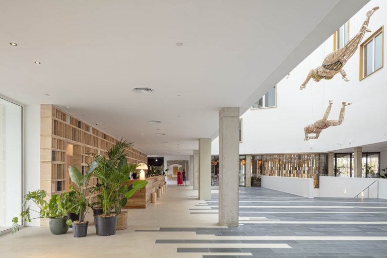 El hall del Atzavara Hotel & Spa tiene una gran cubierta acristalada de la que cuelgan diferentes figuras artesanales de madera. ©Adrià Goula