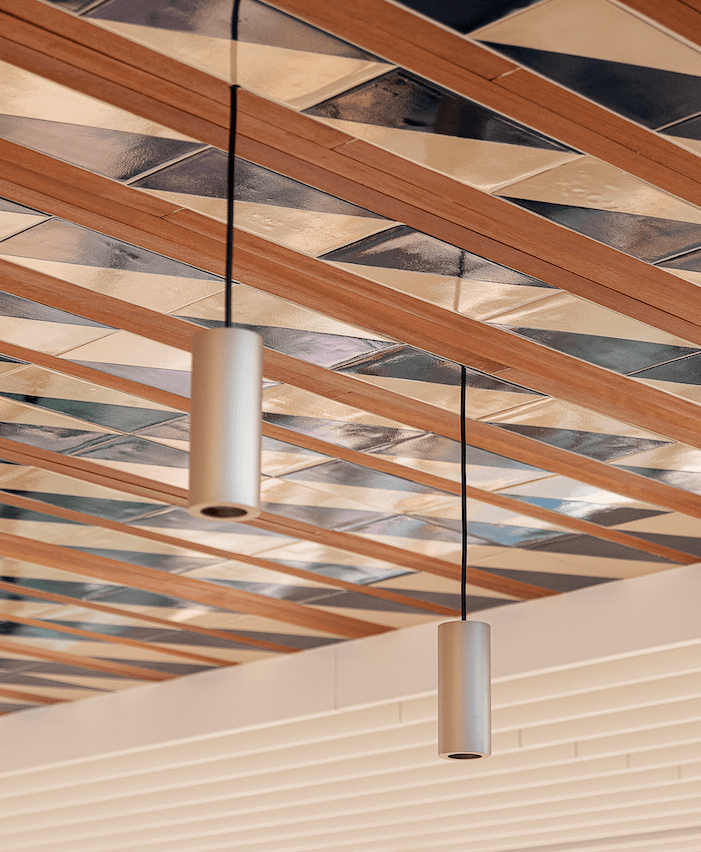 El singular techo central compuesto por piezas de alicatado se combina con unas lámparas tubulares de metal. ©Antoni Perelló